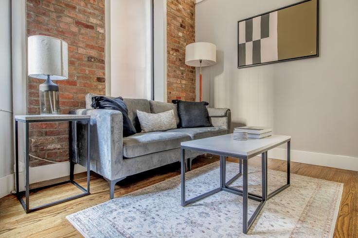 Sala de estar elegantemente projetada com móveis modernos em um apartamento no 246 Mott Street em Manhattan, New York Sala de estar elegantemente projetada com móveis modernos em um apartamento no 246 Mott Street em Manhattan, New York