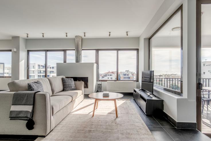 Sala de estar elegantemente projetada com móveis modernos em um apartamento no Pandrosou II em South Athens, Athens