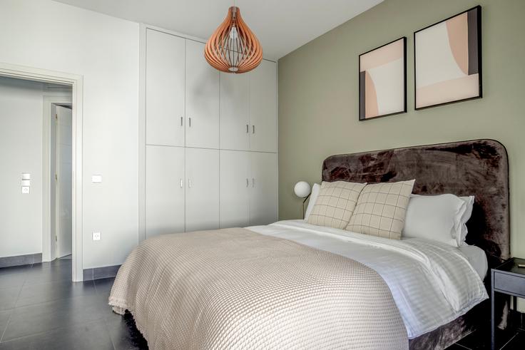 Quarto principal aconchegante com cama grande, iluminação suave e móveis elegantes em um apartamento mobiliado no Pandrosou II em South Athens, Athens