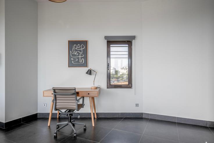 Área de escritório com uma mesa elegante e uma cadeira de apoio em um apartamento no Pandrosou II em South Athens, Athens