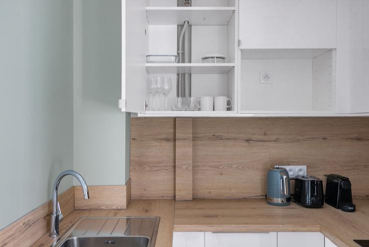 Functional and stylish kitchen with top-of-the-line equipment in an upscale apartment at Maubeuge 82 in 9th arrondissement, Paris