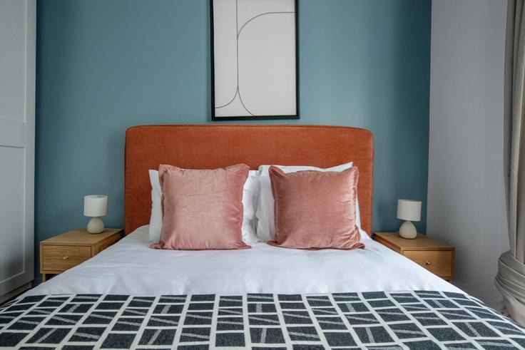Cozy master bedroom with a large bed, soft lighting, and stylish furniture in a furnished apartment at Maubeuge 82 in 9th arrondissement, Paris