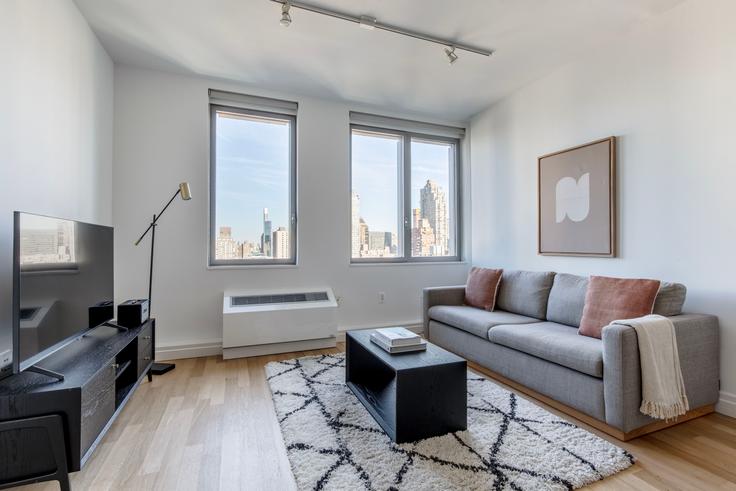 Sala de estar elegantemente projetada com móveis modernos em um apartamento no Forte Select At Mercedes House em Manhattan, New York