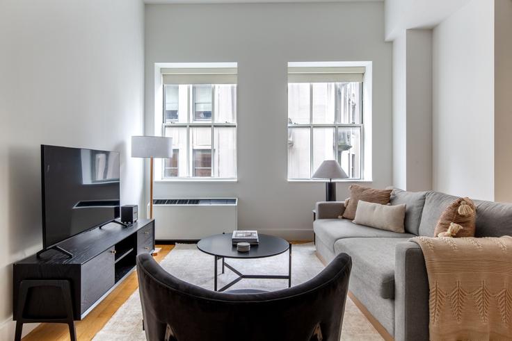 Elegantly designed living room with modern furnishings in an apartment at 63 Wall Street in Financial District, New York