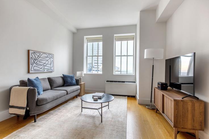 Elegantly designed living room with modern furnishings in an apartment at 63 Wall Street in Financial District, New York