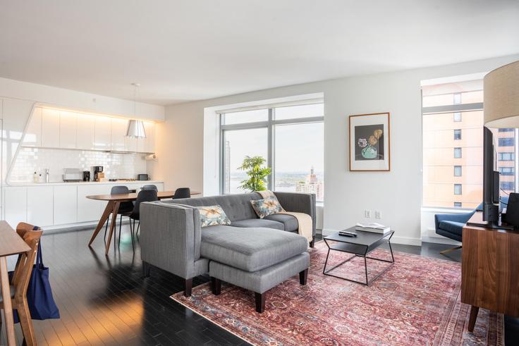 Sala de estar elegantemente projetada com móveis modernos em um apartamento no 123 Washington em Manhattan, New York Sala de estar elegantemente projetada com móveis modernos em um apartamento no 123 Washington em Manhattan, New York