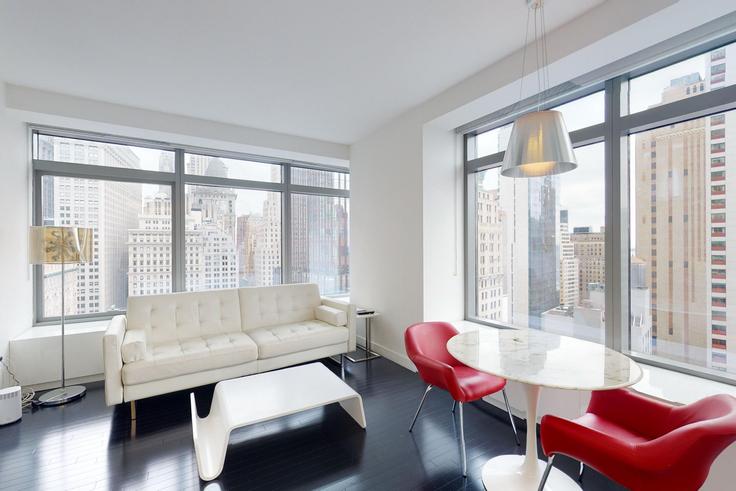 Sala de estar elegantemente projetada com móveis modernos em um apartamento no 123 Washington em Manhattan, New York Sala de estar elegantemente projetada com móveis modernos em um apartamento no 123 Washington em Manhattan, New York