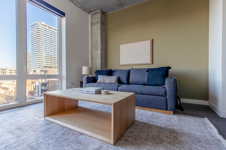 Sala de estar elegantemente projetada com móveis modernos em um apartamento no Hugo em Chicago, Chicago Sala de estar elegantemente projetada com móveis modernos em um apartamento no Hugo em Chicago, Chicago
