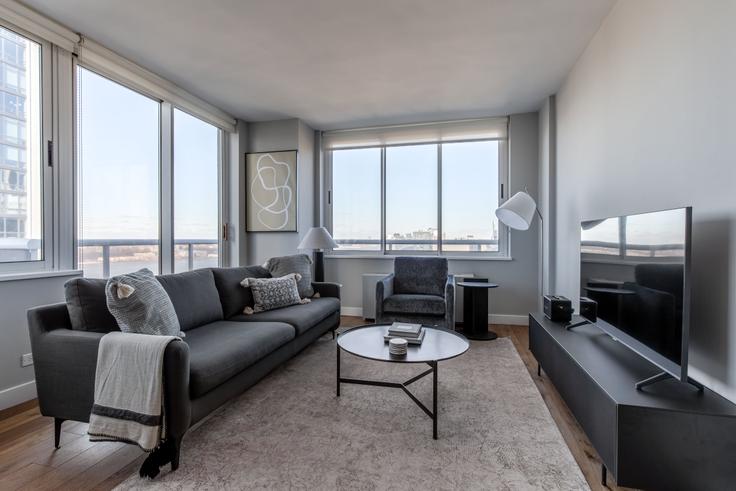 Elegante sala de estar con mobiliario moderno en un apartamento en Riverbank en Manhattan, New York Elegante sala de estar con mobiliario moderno en un apartamento en Riverbank en Manhattan, New York