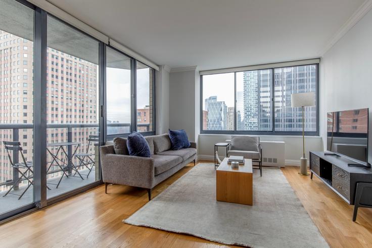 Salle de séjour élégante avec mobilier moderne dans un appartement à The Ritz Plaza à Manhattan, New York Salle de séjour élégante avec mobilier moderne dans un appartement à The Ritz Plaza à Manhattan, New York