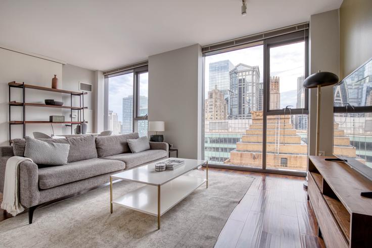 Sala de estar elegantemente projetada com móveis modernos em um apartamento no Lake & Wells Apartments em The Loop, Chicago