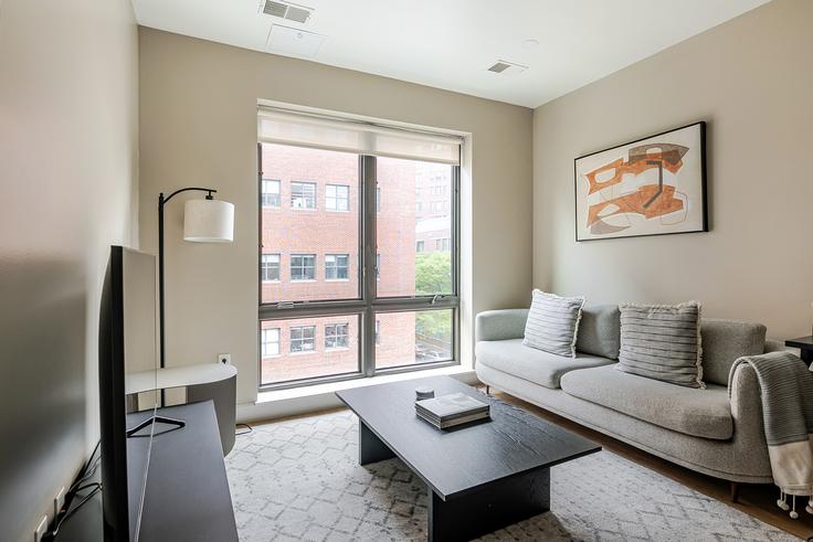 Sala de estar elegantemente projetada com móveis modernos em um apartamento no Axiom em Cambridge, Cambridge Sala de estar elegantemente projetada com móveis modernos em um apartamento no Axiom em Cambridge, Cambridge