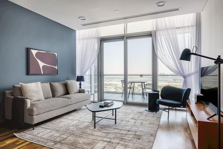 Chic living room with minimalist design from a furnished apartment in Burj Daman, Dubai