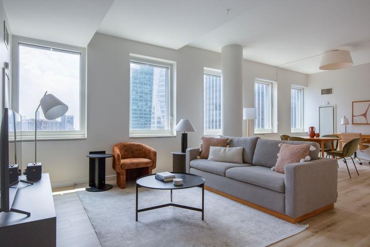 Sala de estar elegantemente projetada com móveis modernos em um apartamento no Cassa em Midtown, New York