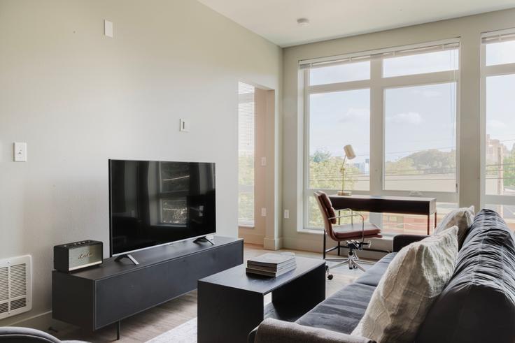 Elegantly designed living room with modern furnishings in an apartment at Tapestry Apartments in Seattle, Seattle