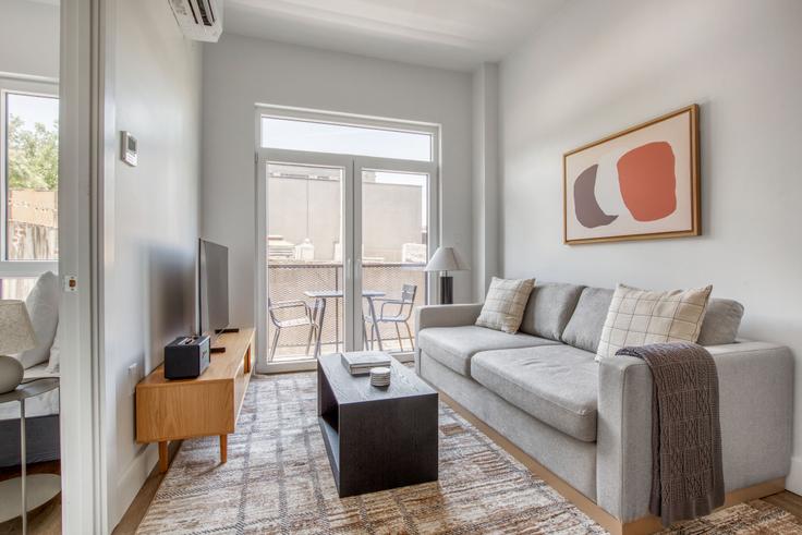 Sala de estar elegantemente projetada com móveis modernos em um apartamento no 82 Fourth Avenue em Brooklyn, New York Sala de estar elegantemente projetada com móveis modernos em um apartamento no 82 Fourth Avenue em Brooklyn, New York