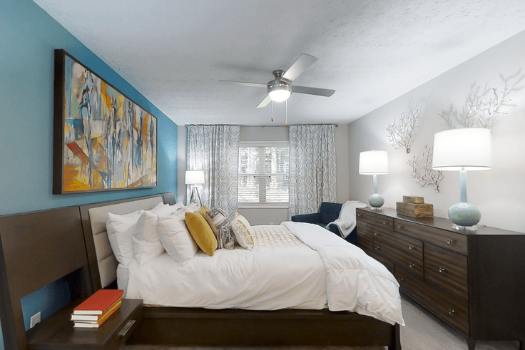 Acogedor dormitorio principal con una cama grande, iluminación suave y muebles con estilo en un apartamento amueblado en Cortland at the Village en Smyrna, Smyrna