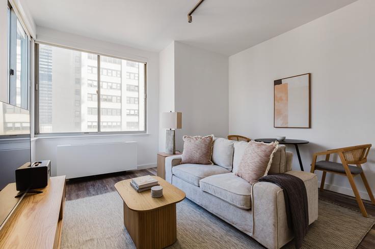 Elegante sala de estar con mobiliario moderno en un apartamento en The Aurora en Manhattan, New York Elegante sala de estar con mobiliario moderno en un apartamento en The Aurora en Manhattan, New York