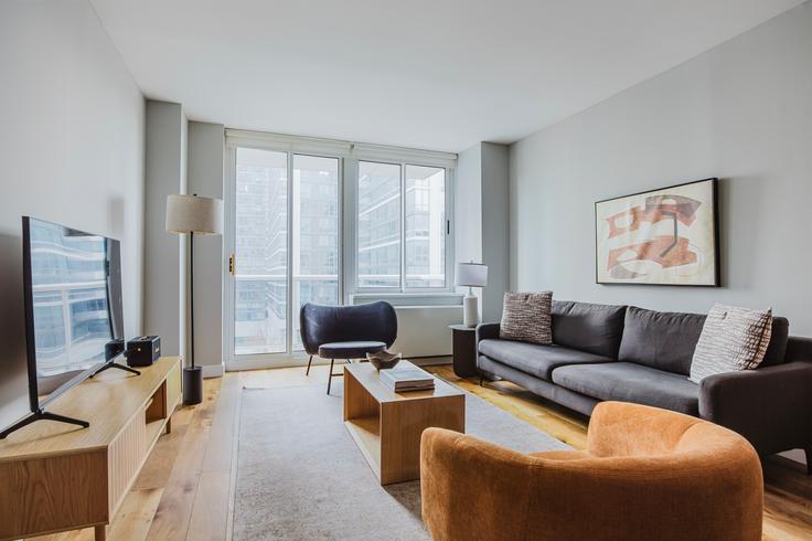 Elegante sala de estar con mobiliario moderno en un apartamento en Riverbank en Manhattan, New York Elegante sala de estar con mobiliario moderno en un apartamento en Riverbank en Manhattan, New York