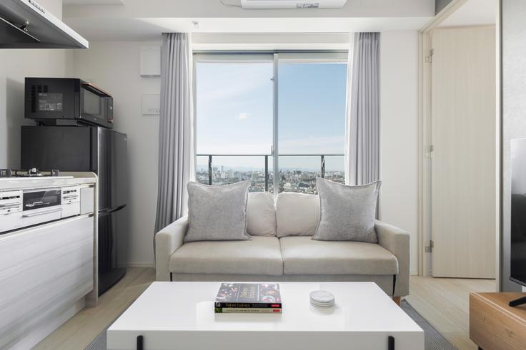 Elegante sala de estar con mobiliario moderno en un apartamento en The Parkhabio Mejiro Tower en Toshima City, Tokyo Elegante sala de estar con mobiliario moderno en un apartamento en The Parkhabio Mejiro Tower en Toshima City, Tokyo