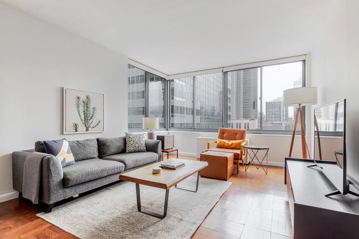 Salle de séjour élégante avec mobilier moderne dans un appartement à The Ritz Plaza à Manhattan, New York Salle de séjour élégante avec mobilier moderne dans un appartement à The Ritz Plaza à Manhattan, New York