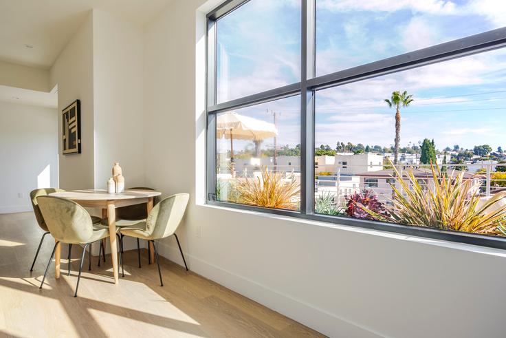 Dining table with stylish chairs in an apartment at 611 N. Virgil in Los Angeles, Los Angeles