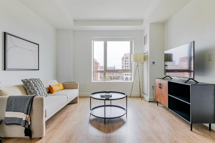 Elegante sala de estar con mobiliario moderno en un apartamento en One Greenway en Boston, Boston Elegante sala de estar con mobiliario moderno en un apartamento en One Greenway en Boston, Boston