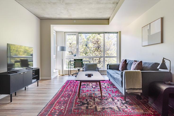 Sala de estar elegantemente projetada com móveis modernos em um apartamento no The Century Apartments em Seattle, Seattle Sala de estar elegantemente projetada com móveis modernos em um apartamento no The Century Apartments em Seattle, Seattle