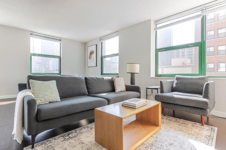 Sala de estar elegantemente projetada com móveis modernos em um apartamento no West77 em Chicago, Chicago Sala de estar elegantemente projetada com móveis modernos em um apartamento no West77 em Chicago, Chicago
