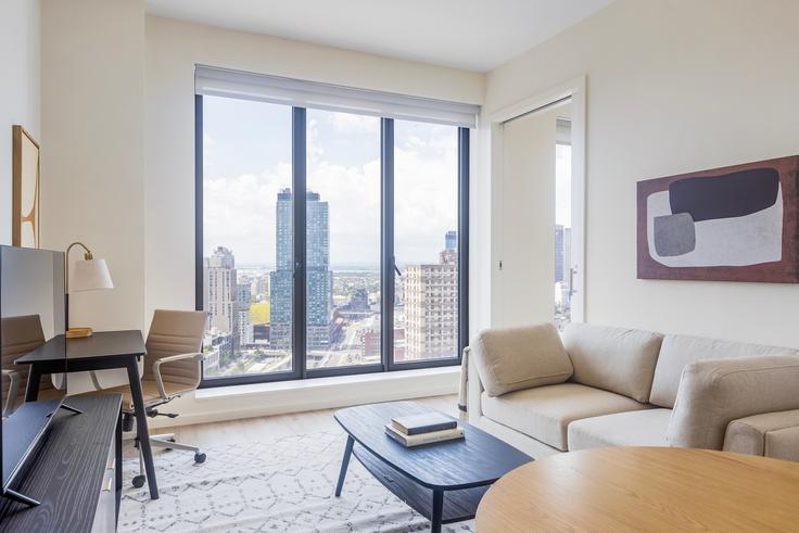 Salle de séjour élégante avec mobilier moderne dans un appartement à The Axel à Brooklyn, New York Salle de séjour élégante avec mobilier moderne dans un appartement à The Axel à Brooklyn, New York