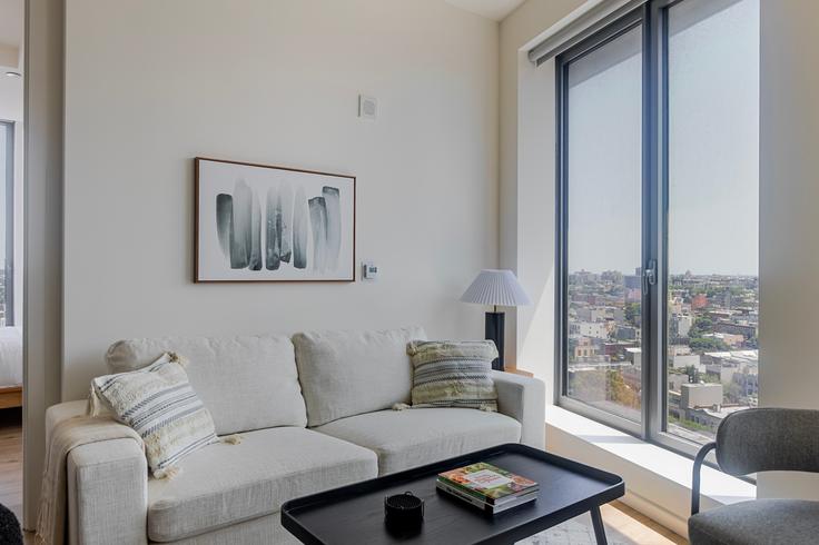 Salle de séjour élégante avec mobilier moderne dans un appartement à The Axel à Brooklyn, New York Salle de séjour élégante avec mobilier moderne dans un appartement à The Axel à Brooklyn, New York