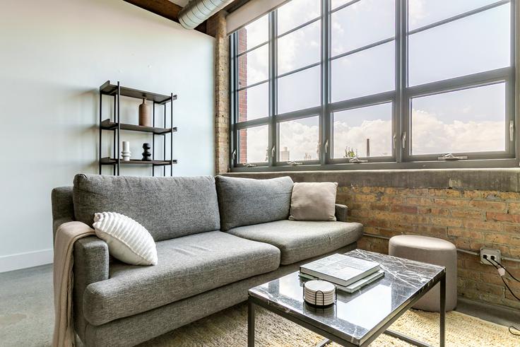 Elegant gestaltetes Wohnzimmer mit moderner Einrichtung in einer Wohnung im Southport Lofts in Chicago, Chicago