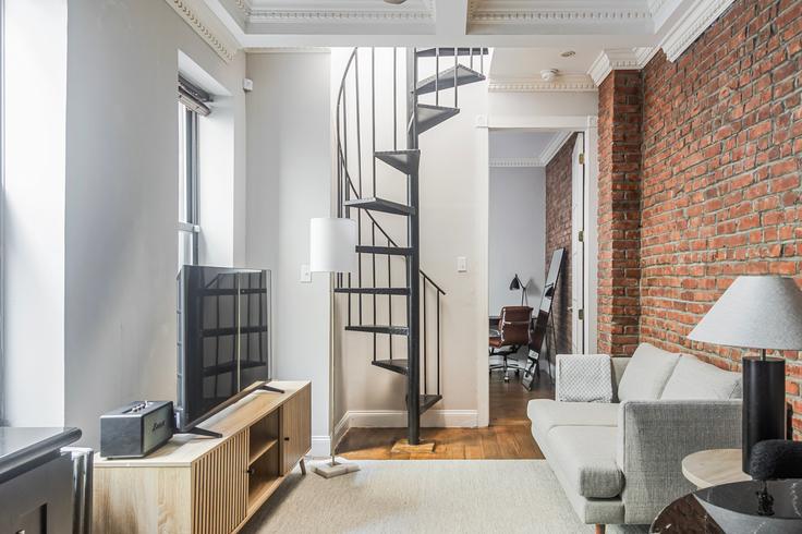 Sala de estar elegantemente projetada com móveis modernos em um apartamento no 20 Prince Street em Manhattan, New York Sala de estar elegantemente projetada com móveis modernos em um apartamento no 20 Prince Street em Manhattan, New York